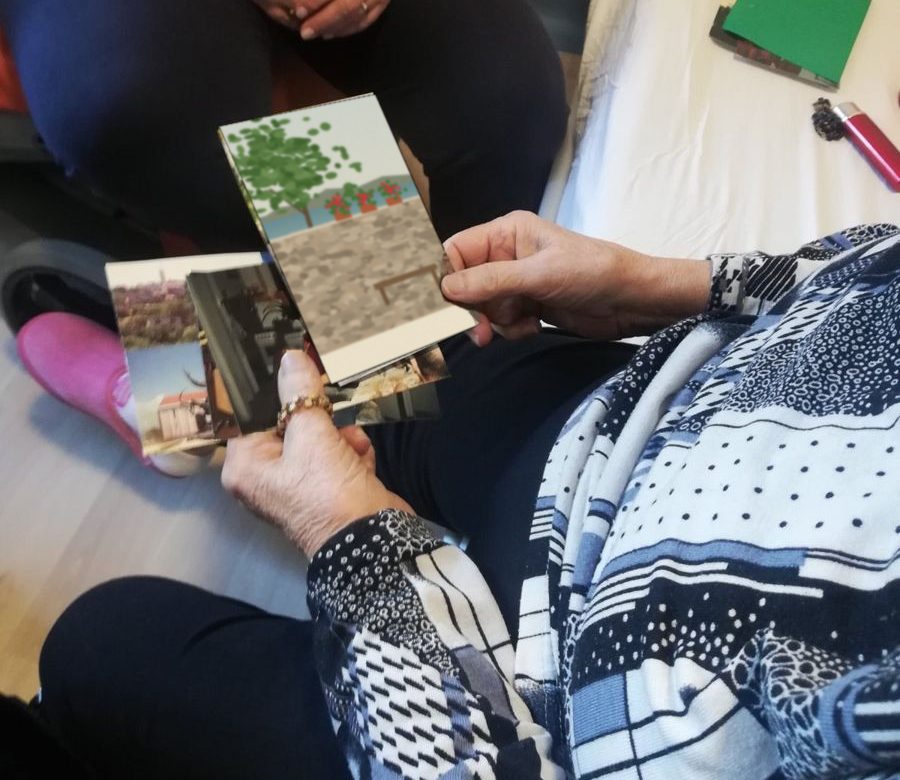 Starija osoba drži stare fotografije